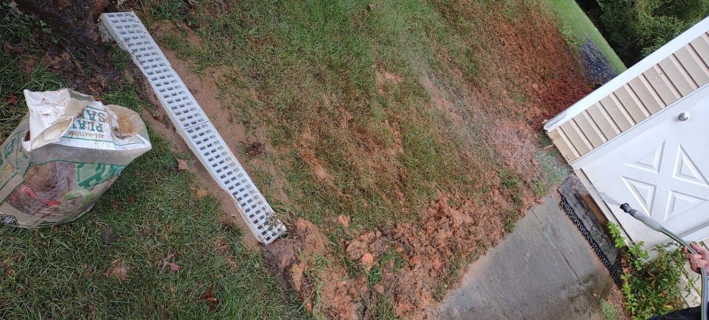 An aerial view of a lawn with a drain in the middle of it.