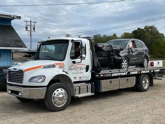 A tow truck with a car on the back of it.