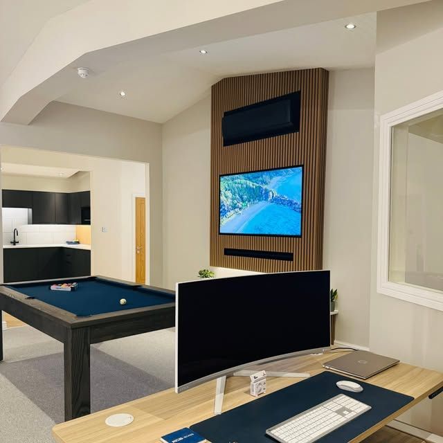 Modern conference room with wood tables, black chairs, floor-to-ceiling windows, and a ceiling-mounted AC unit