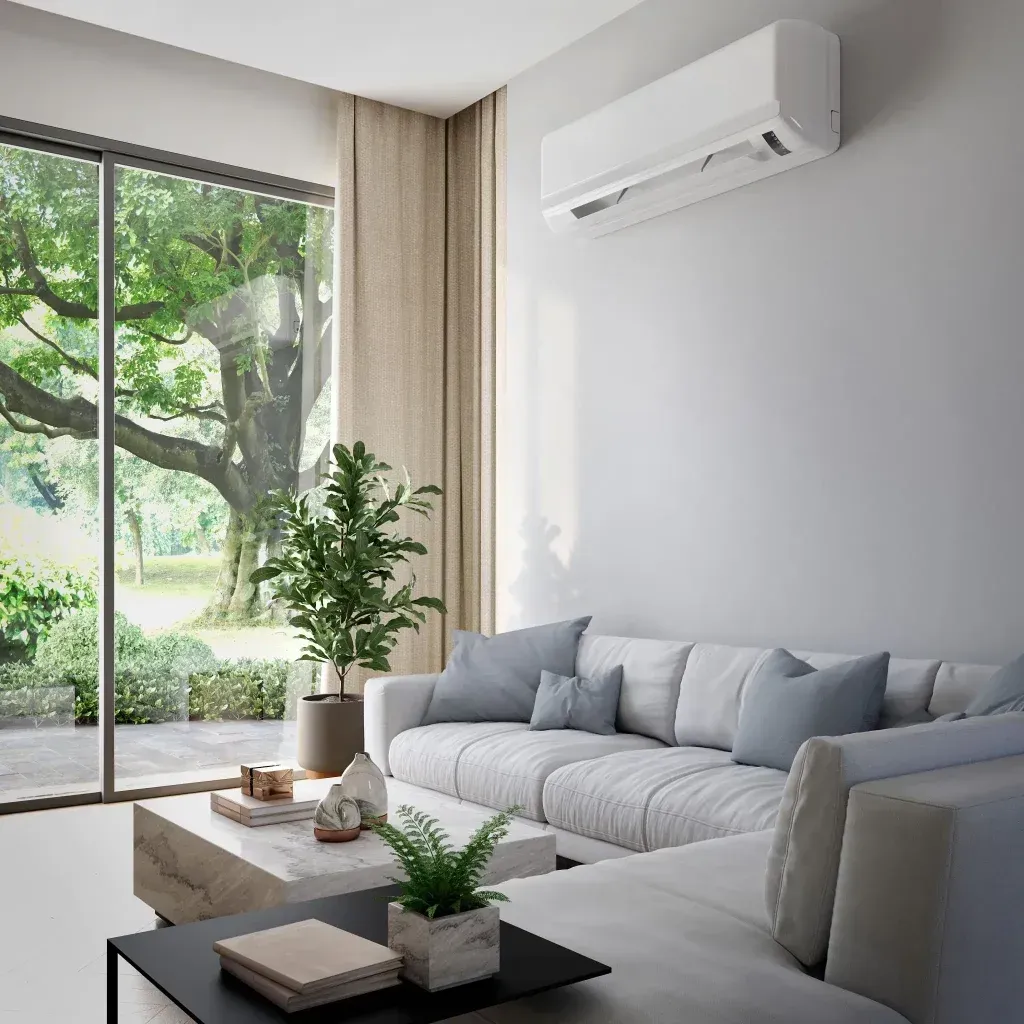 Bright modern living room with gray sofa, coffee table, indoor plant, and large sliding glass door.