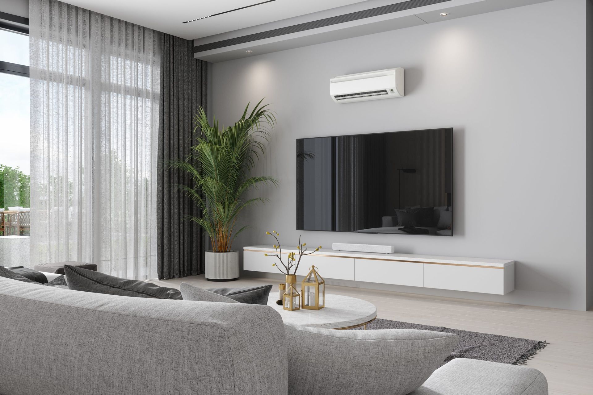 Modern living room with gray sofa, wall-mounted TV, white console, tall plant, and sheer curtains.