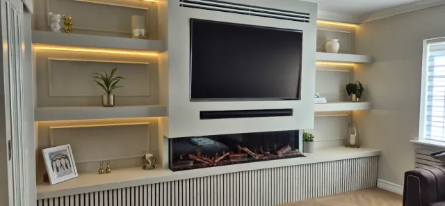 Modern living room with dark sofa, coffee table, and floor-to-ceiling windows overlooking greenery