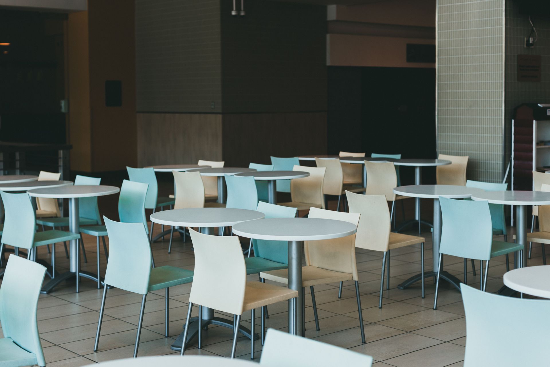 Empty cafeteria with white tables and chairs in a modern indoor space