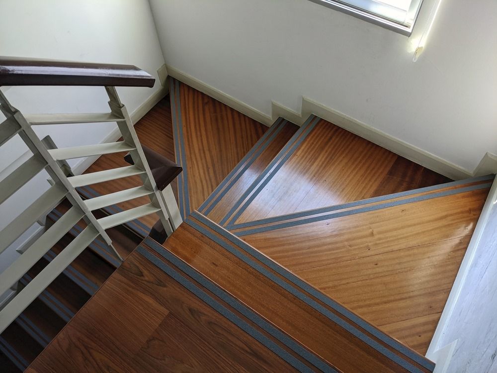 A Wooden Staircase With a White Railing and a Window — Maroochy Floor Sanding in Maroochydore, QLD