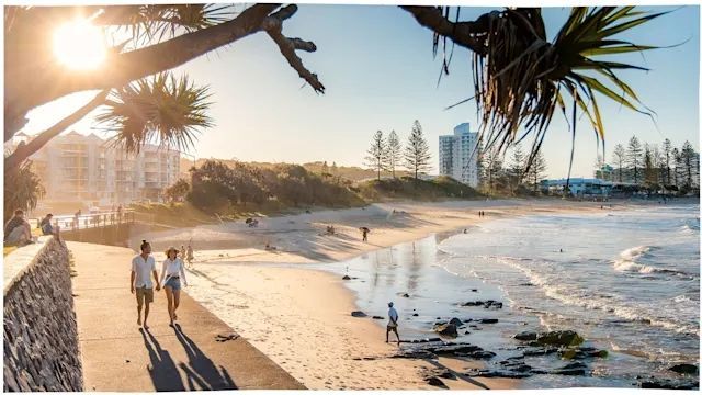 A Couple is Walking Along a Beach Holding Hands — Maroochy Floor Sanding in Maroochydrore, QLD