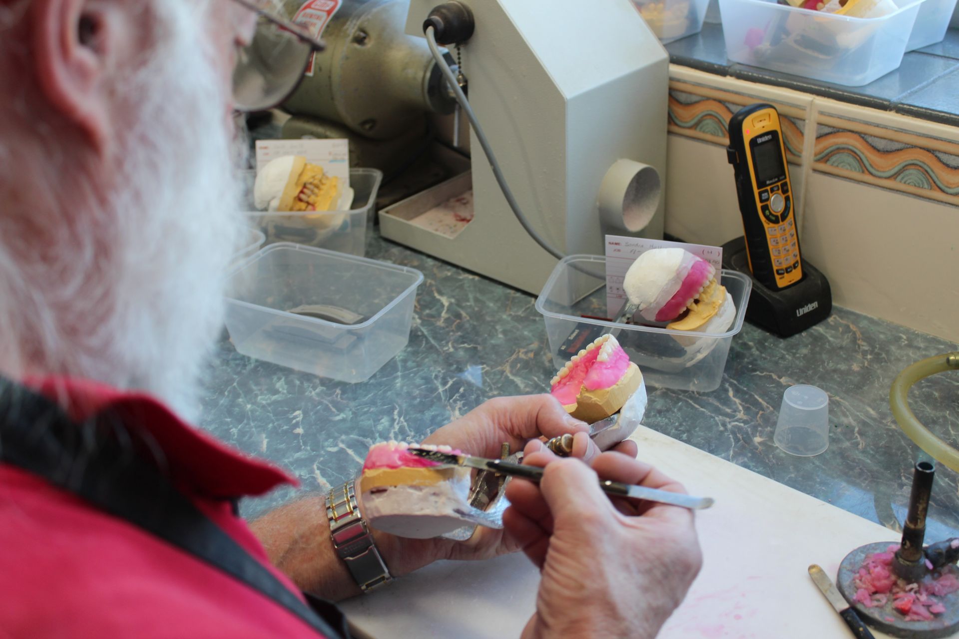 Man working on a partial denture — Dentures in Toukley, NSW