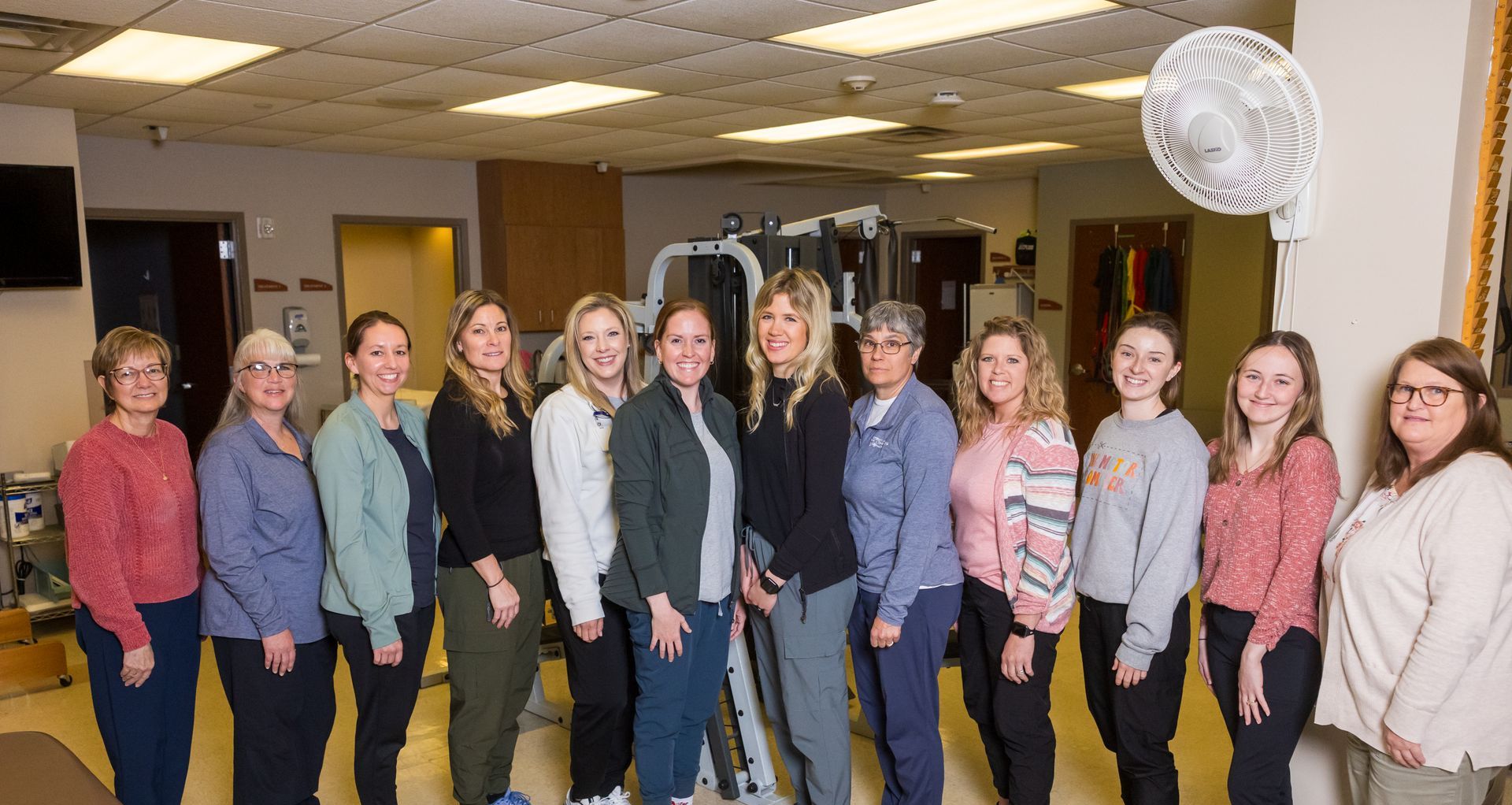Group of healthcare professionals standing in a physical therapy clinic.