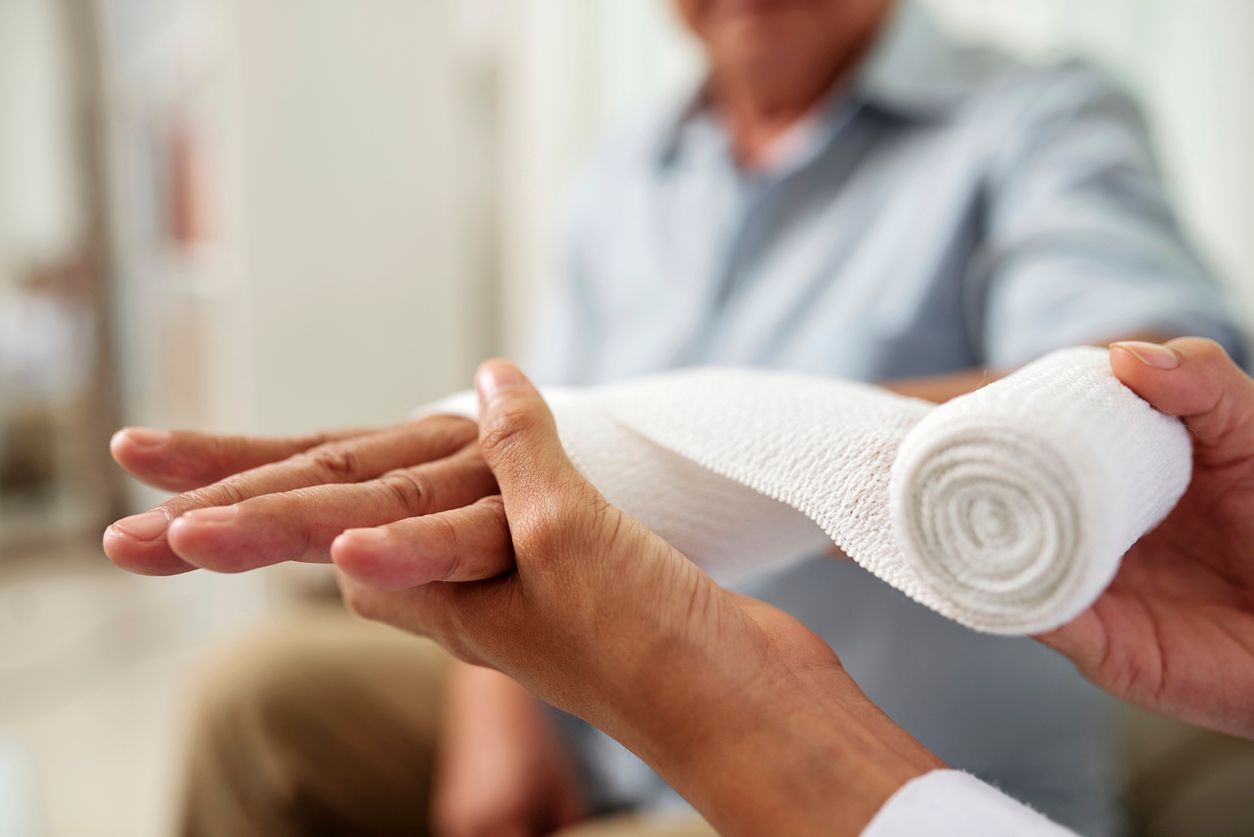 A skilled doctor is carefully wrapping a patient 's wrist with a bandage