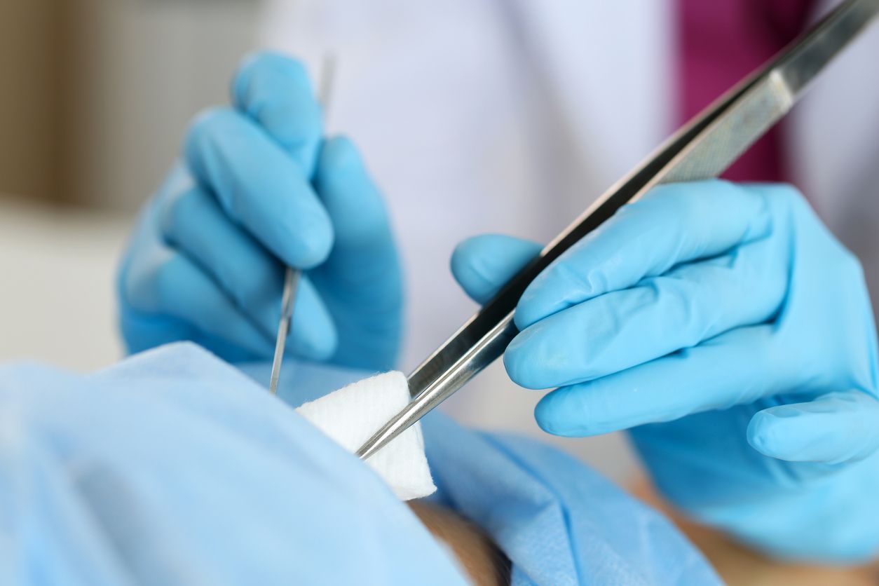 A person is pointing at an EKG monitor with a heartbeat on it.