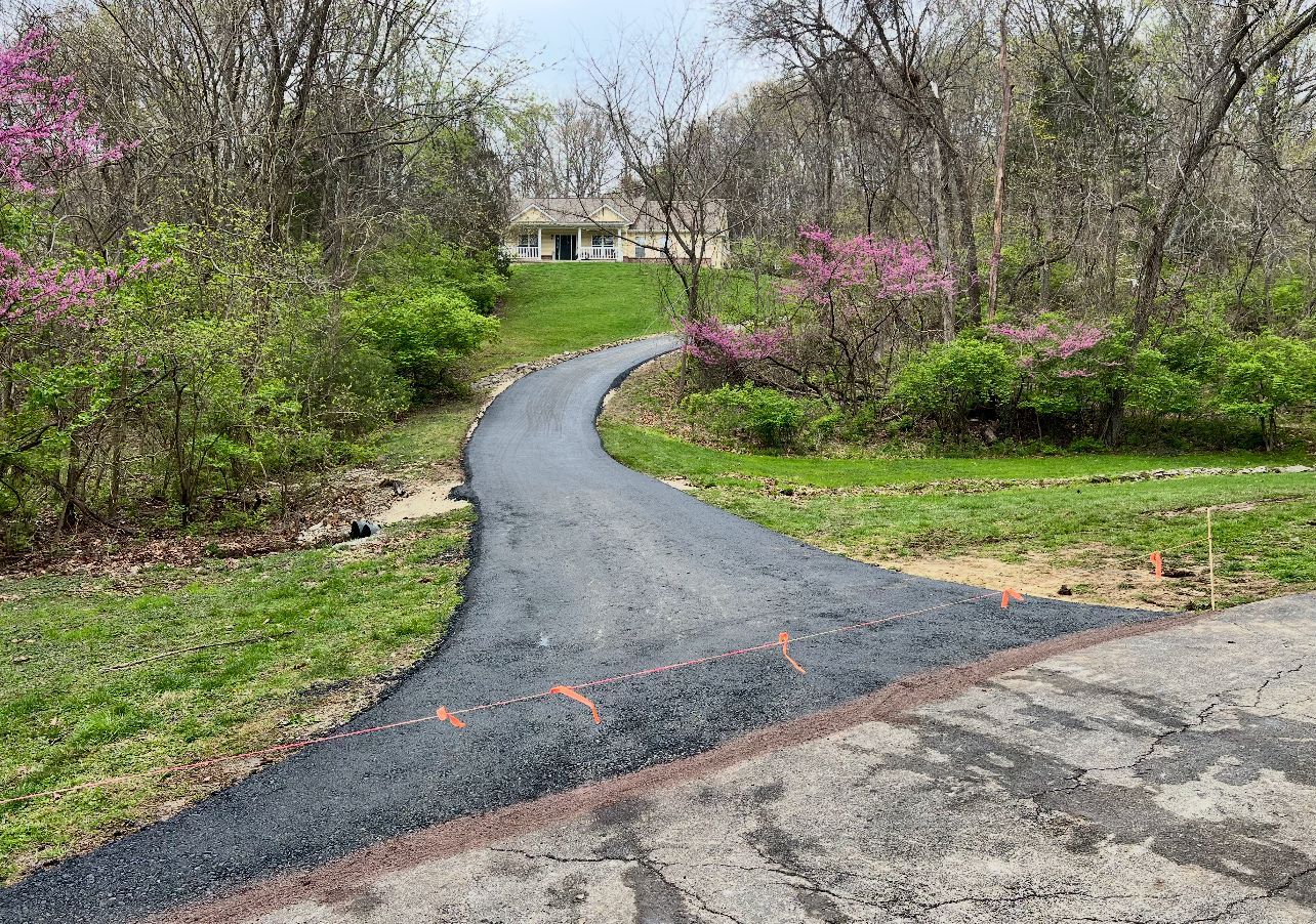 Curving gravel path through a spring garden with blooming pink shrubs and trees