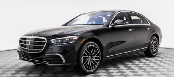 Black luxury sedan on a gray checkered studio floor, front three-quarter view