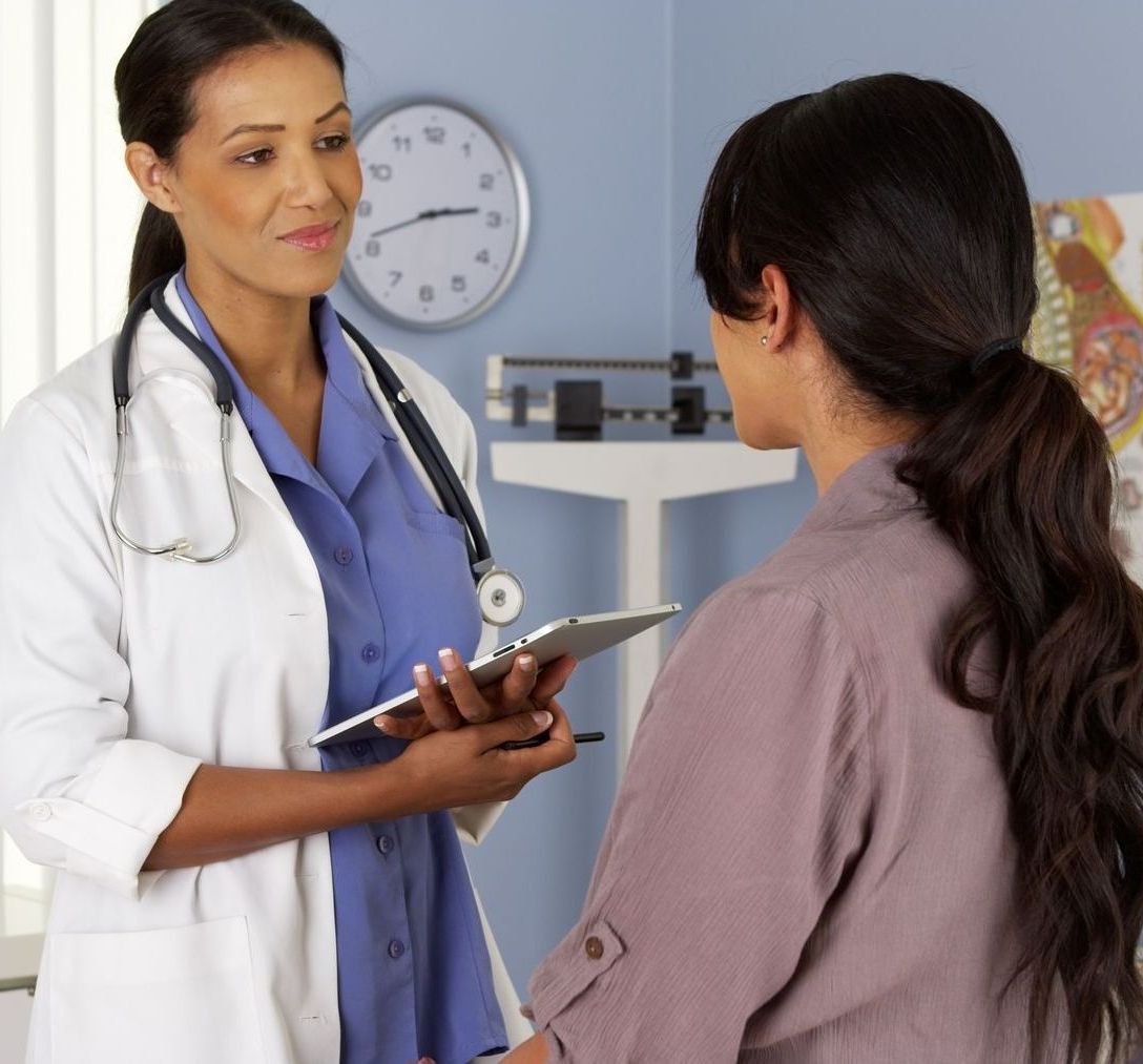 A doctor is talking to a patient who is holding a clipboard
