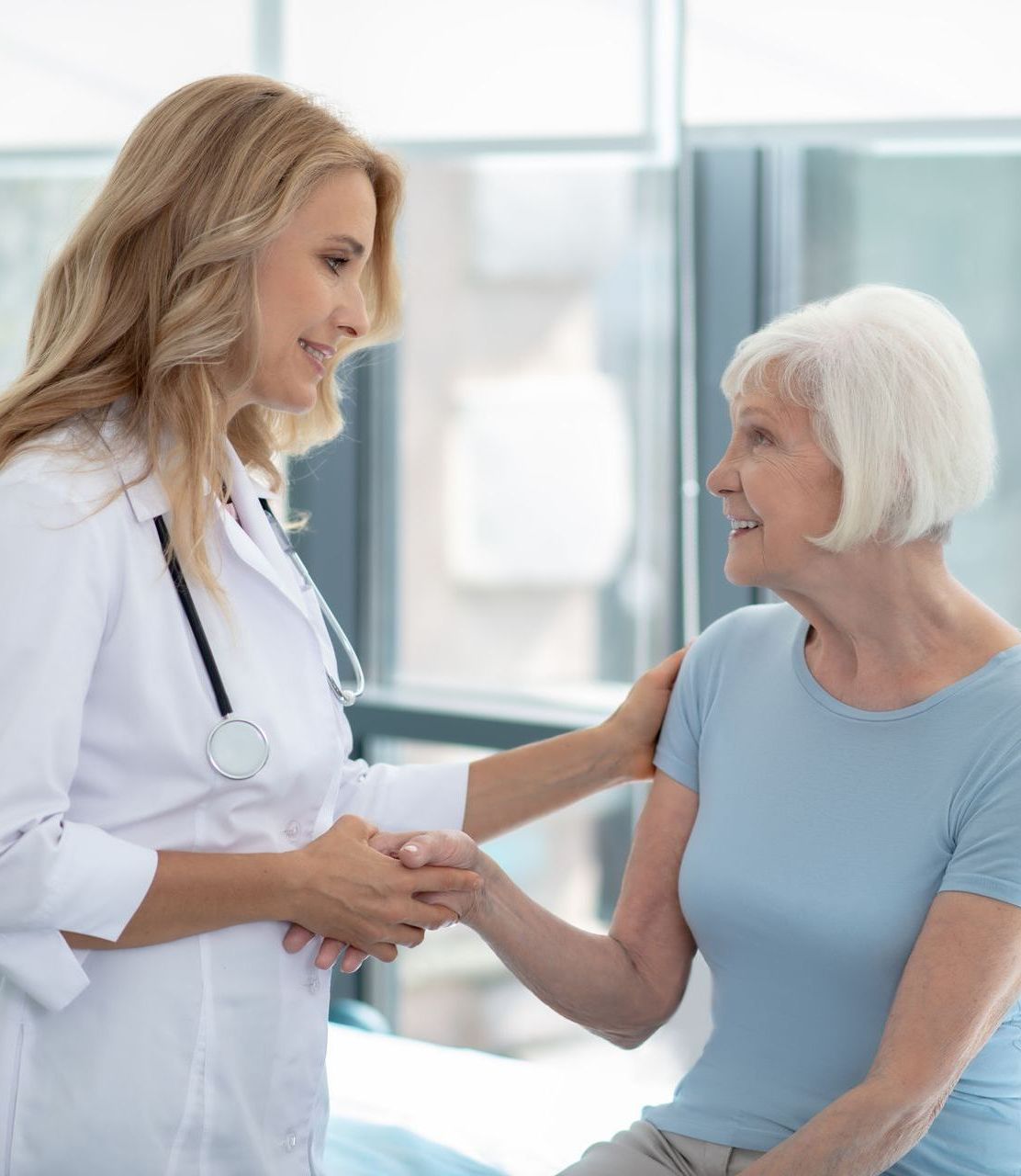 A doctor is shaking hands with an elderly woman