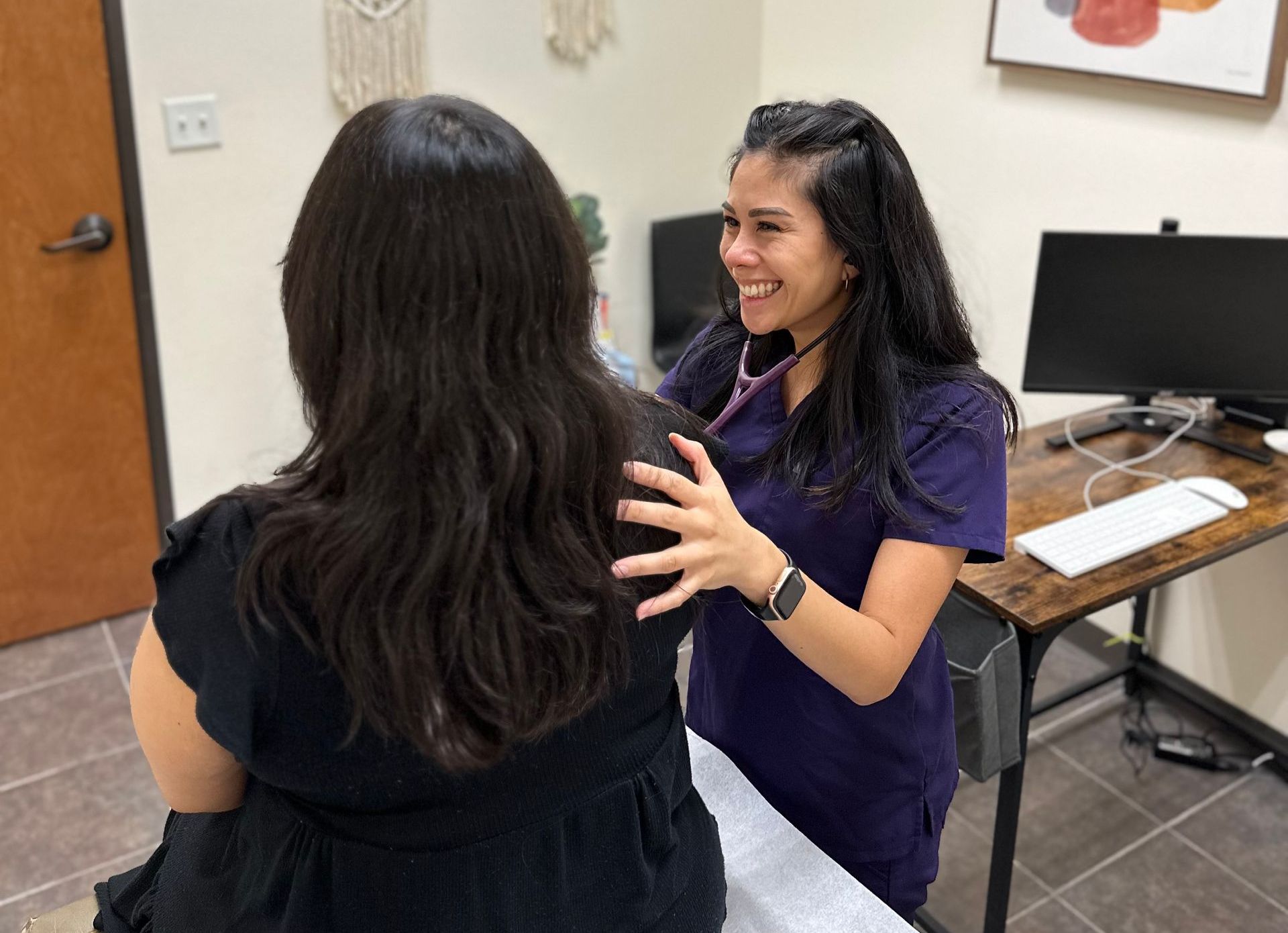 A female doctor is listening to a patient 's heartbeat with a stethoscope.