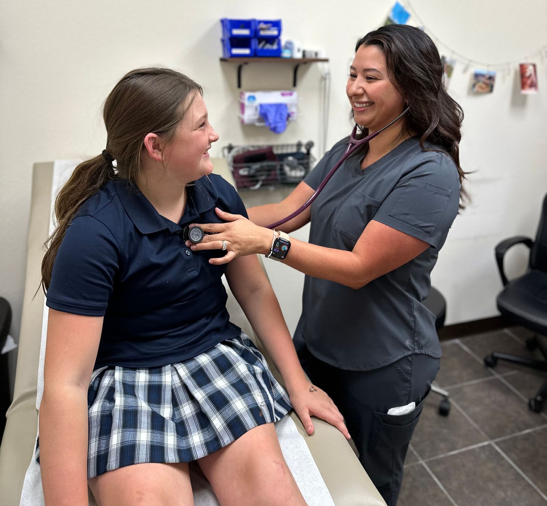 A woman is listening to a girl 's heartbeat with a stethoscope