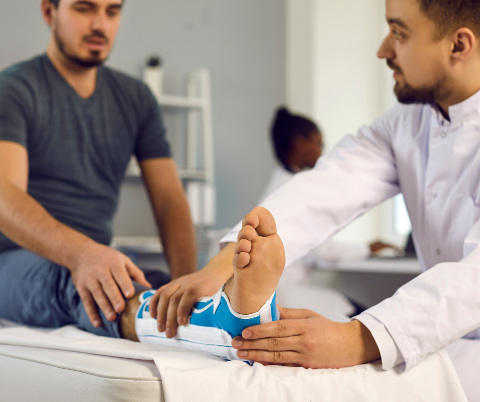 A man is sitting on a bed while a doctor examines his foot.
