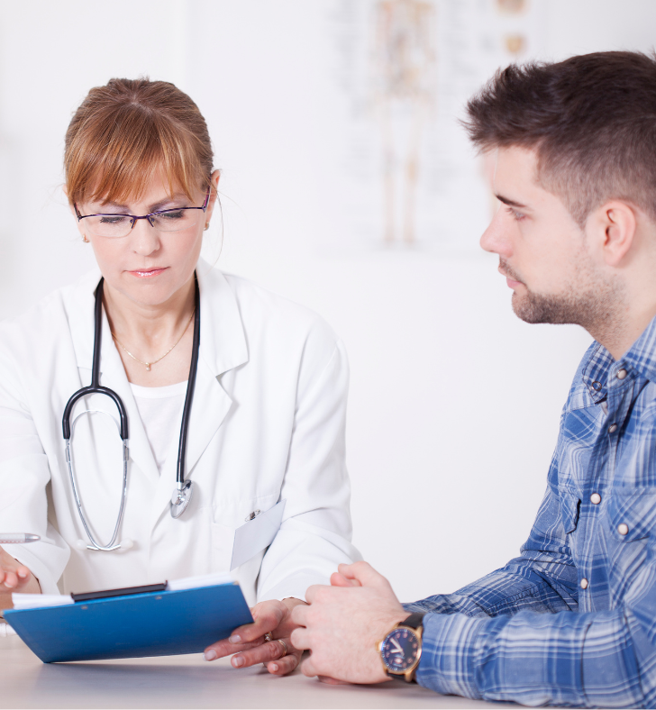A doctor is talking to a patient who is wearing a plaid shirt
