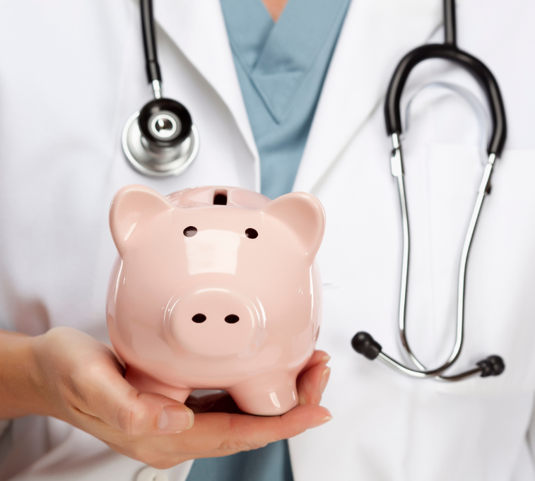 A doctor with a stethoscope around his neck is holding a pink piggy bank
