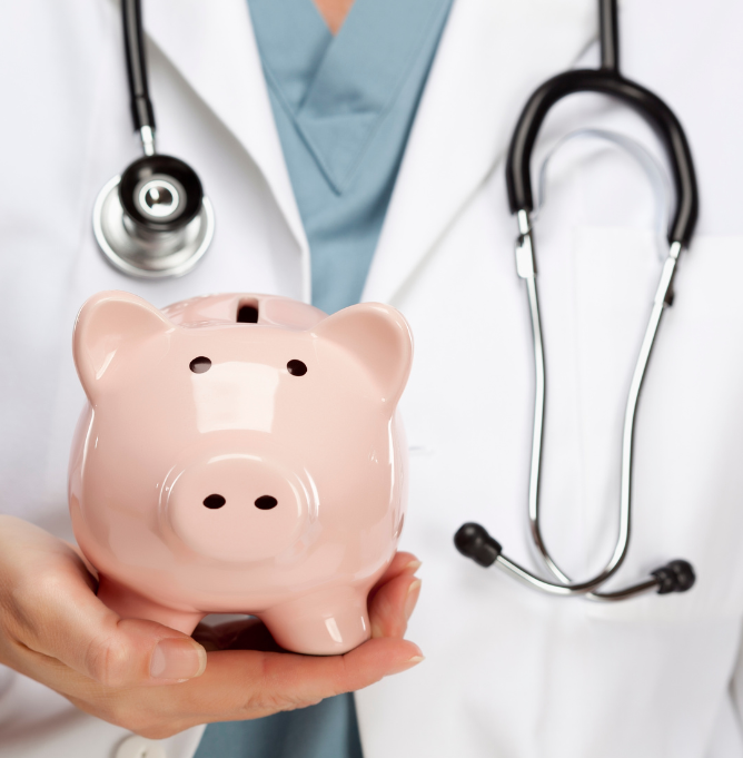 A doctor with a stethoscope around his neck holds a pink piggy bank