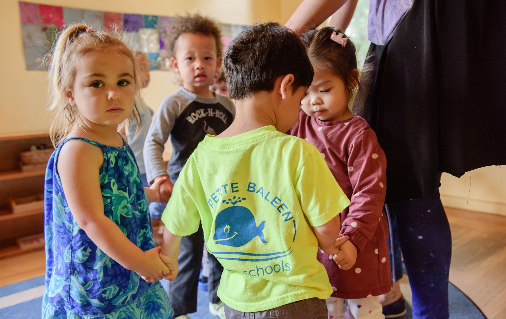 Montessori toddlers holding hands in the classroom