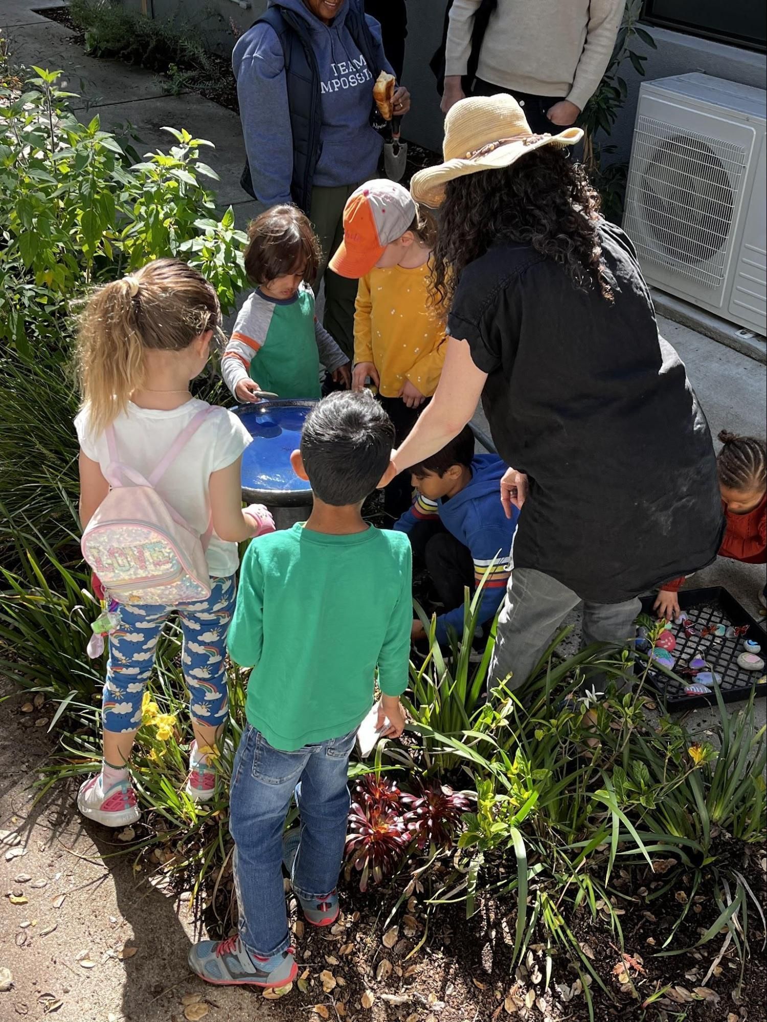Montessori guide and children installing a bird bath