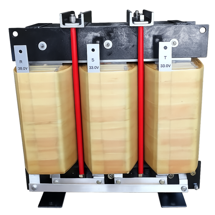 Trasformatore trifase con bobine avvolte, barre rosse e supporti metallici, appoggiato su un pallet.