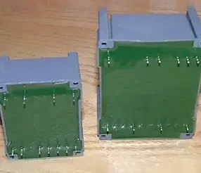 Due scatole di gel per elettroforesi grigie e verdi su una superficie di legno.