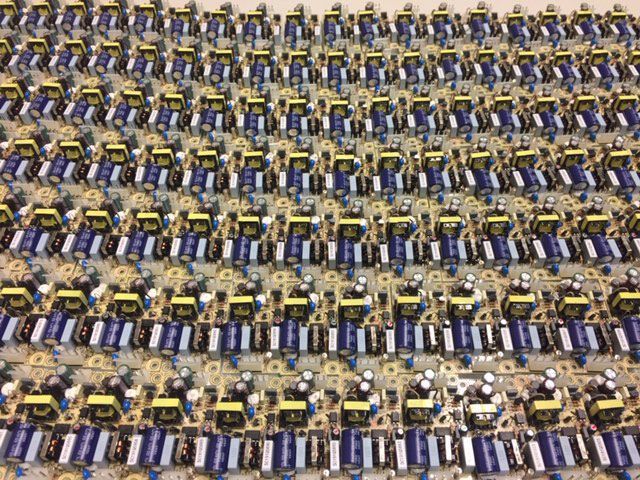 File di circuiti elettronici con componenti blu e gialli.