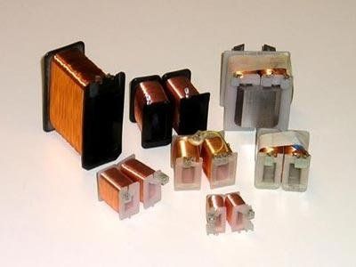 Bobine elettromagnetiche assortite con avvolgimenti in filo di rame di varie dimensioni e forme.