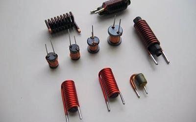 Vari induttori, piccole bobine di filo di rame, disposte su una superficie luminosa.