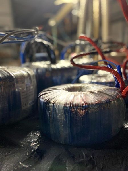 Trasformatori elettrici blu e argento con fili rossi e blu.