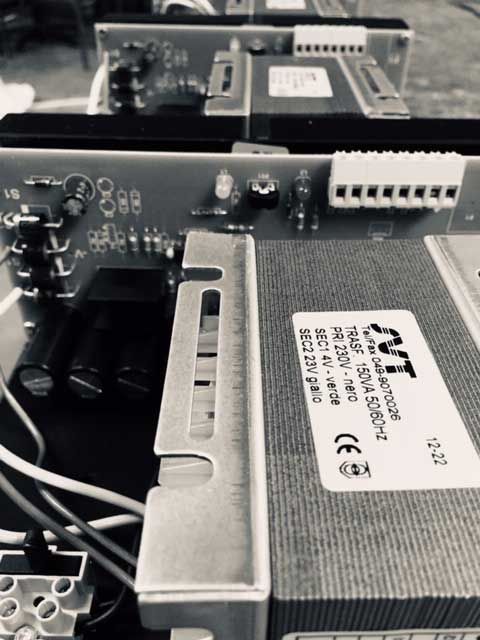 Primo piano dei componenti elettrici, tra cui un trasformatore, un circuito stampato e il cablaggio.
