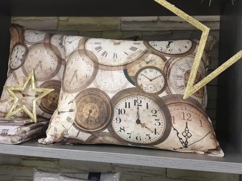 Cuscini con un motivo a quadrante di orologio vintage su una mensola con stelle decorative.