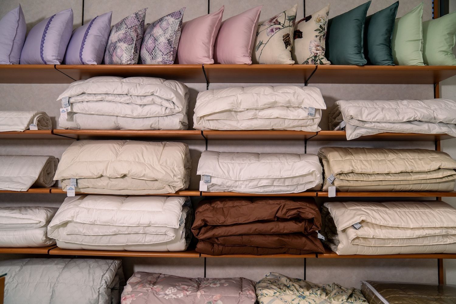 Scaffali con cuscini e coperte piegate di vari colori.