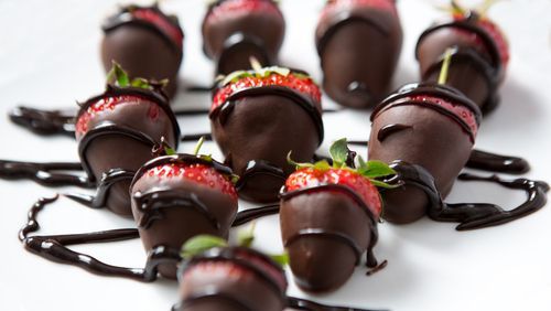 chocolate coated strawberries on plate with chocolate drippings