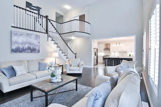 A kitchen with white cabinets and marble counter tops