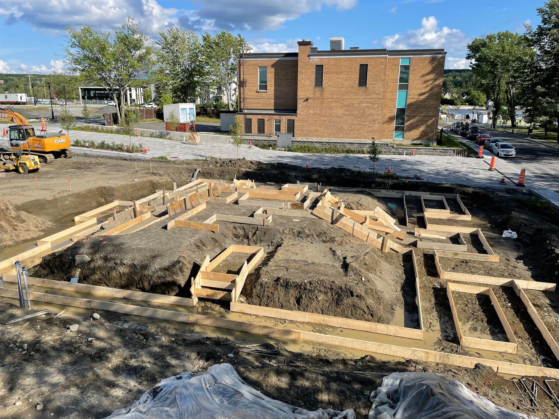 Un chantier de construction avec un grand bâtiment en briques en arrière-plan.