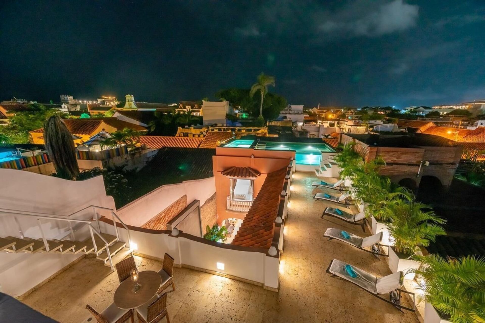 Una vista aérea de un hotel por la noche con una piscina al fondo.