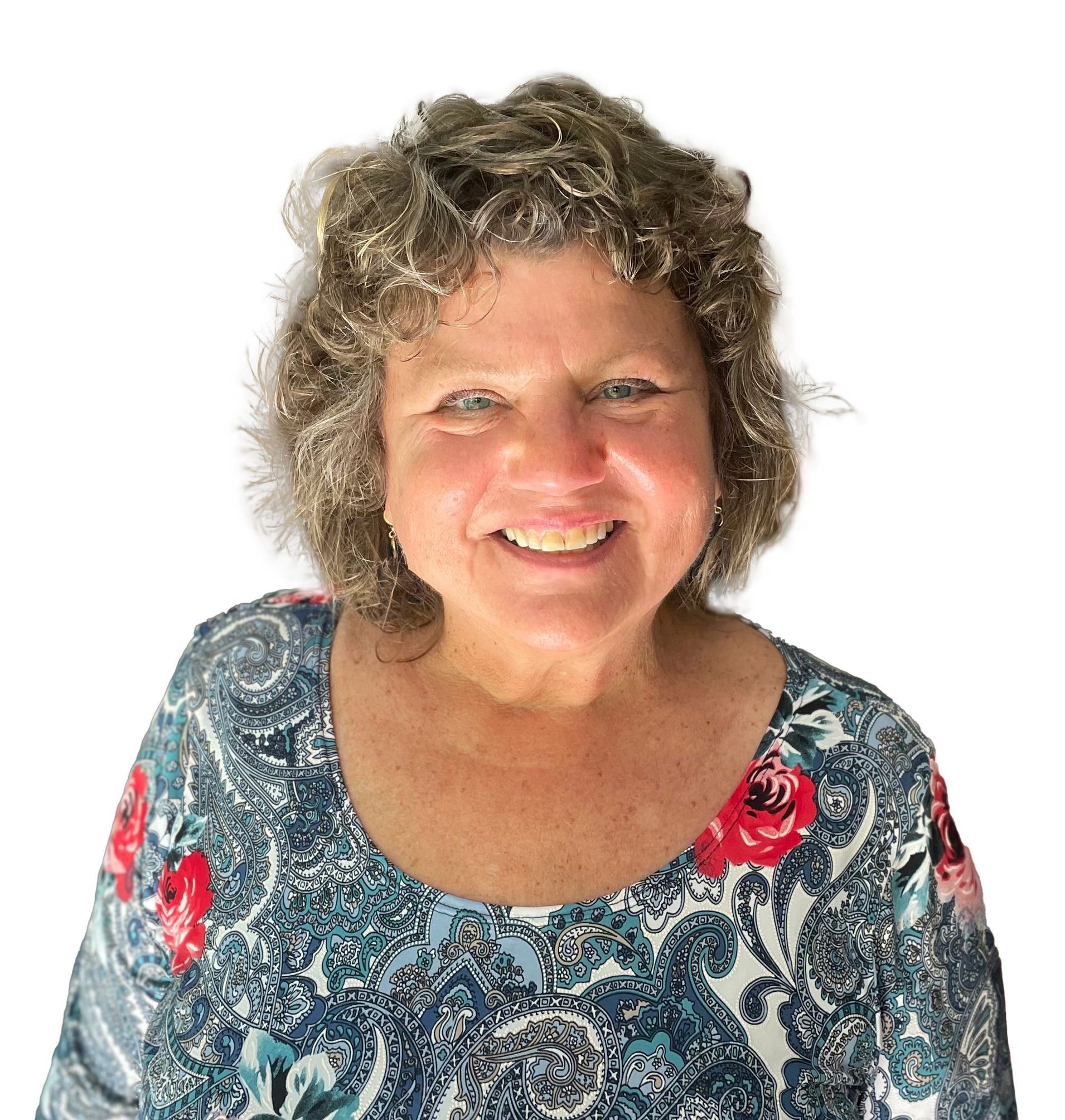A woman is sitting on a chair in front of a brick wall. Ashley Kersey Realtor