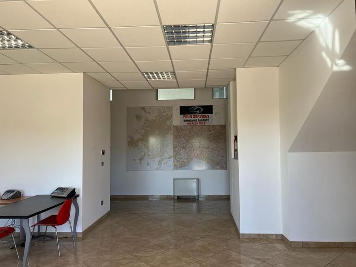 Una stanza con tavolo e sedie e una mappa sul muro