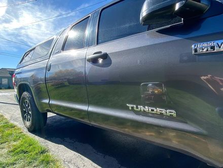 A black toyota tundra truck is parked on the side of the road.