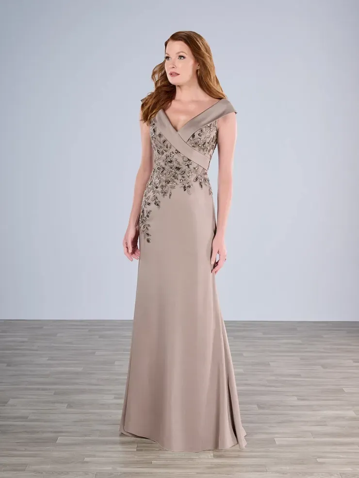 A woman in a long dress is standing on a wooden floor.