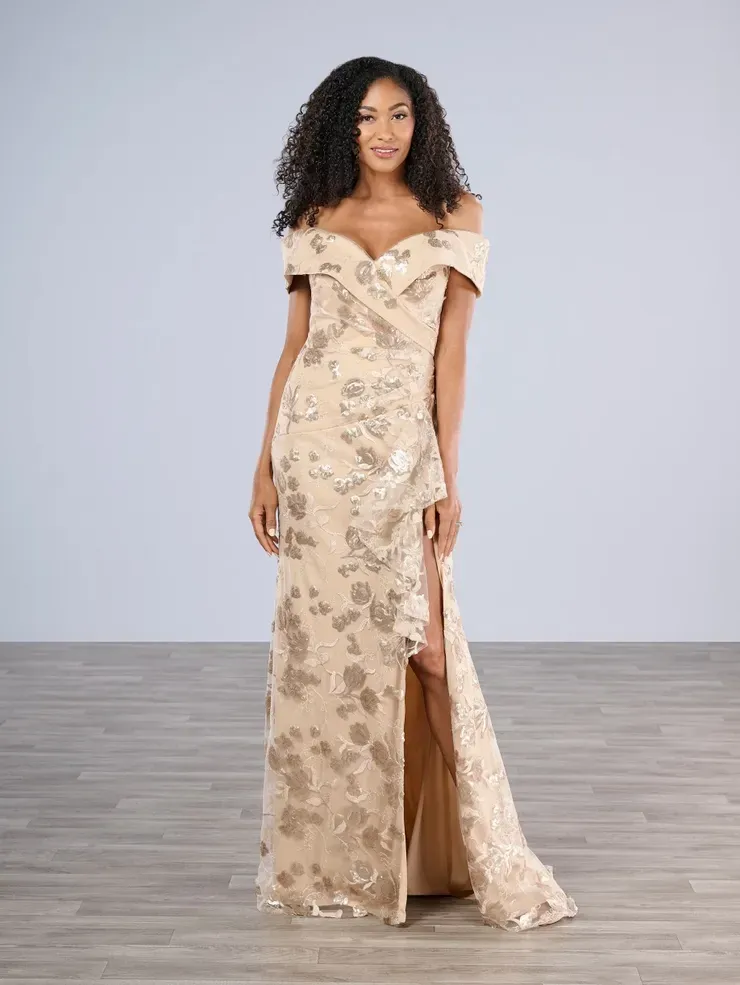 A woman is wearing a long gold dress with a high slit.