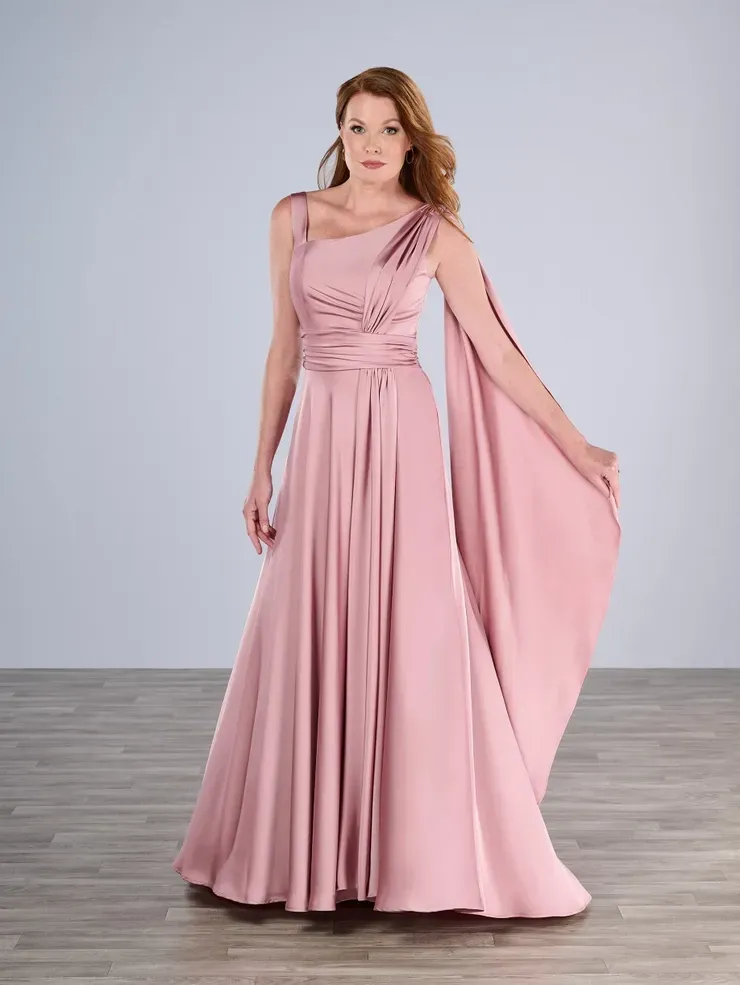 A woman in a long pink dress is standing on a wooden floor.
