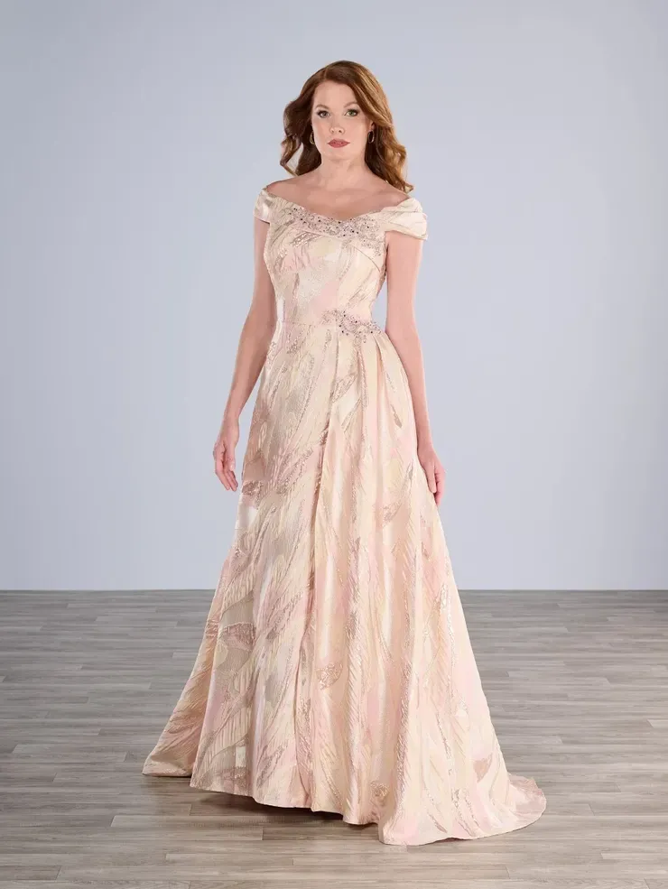 A woman in a long pink dress is standing on a wooden floor.