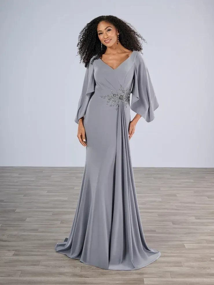 A woman is wearing a long gray dress with long sleeves.