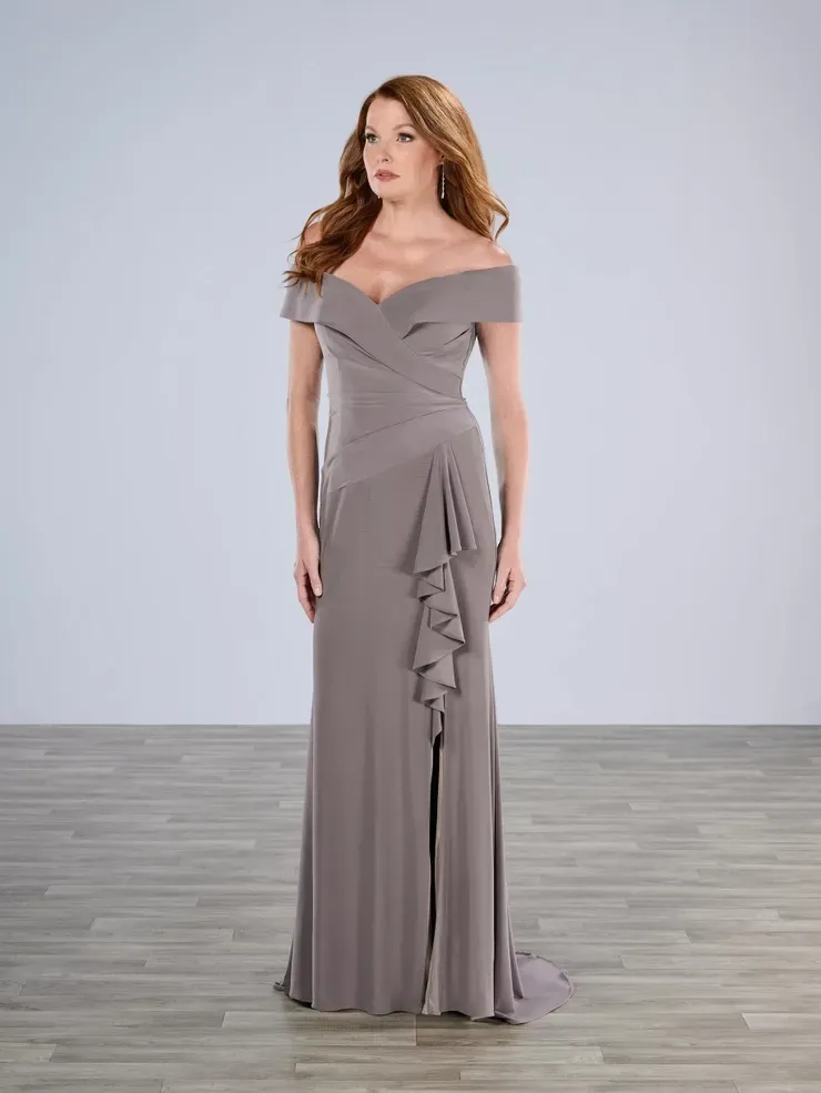 A woman is wearing a gray off the shoulder dress with ruffles.