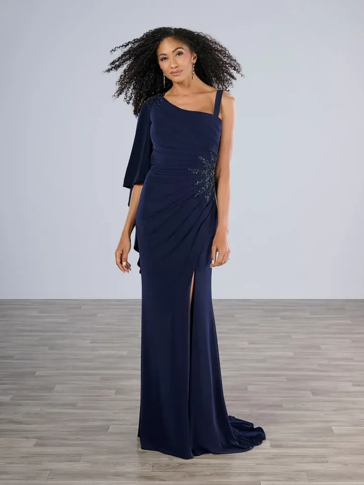 A woman in a long blue dress is standing on a wooden floor.