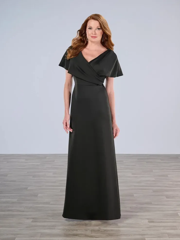 A woman in a black dress is standing on a wooden floor.