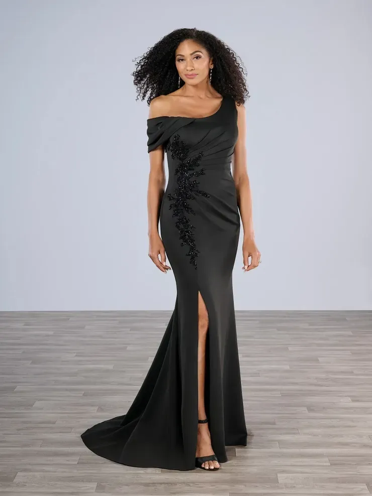 A woman is wearing a black one shoulder dress with a high slit.